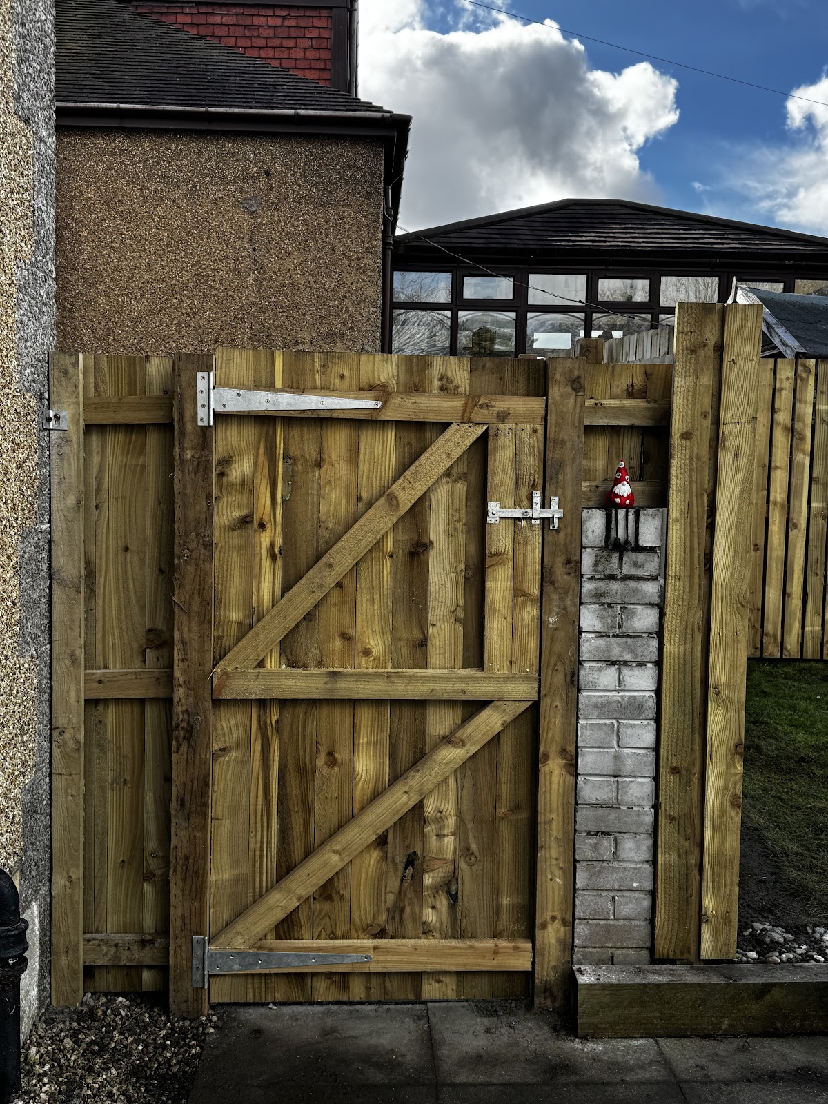 Robust timber garden gate fitted between fence posts