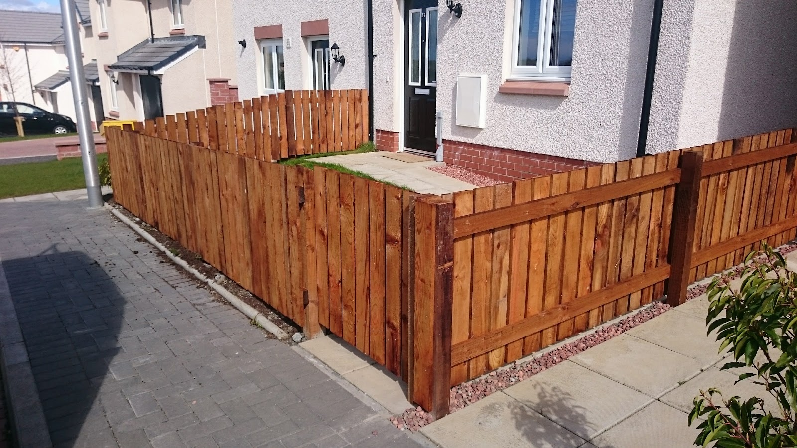 Warm-toned timber fence surrounding the front of a home